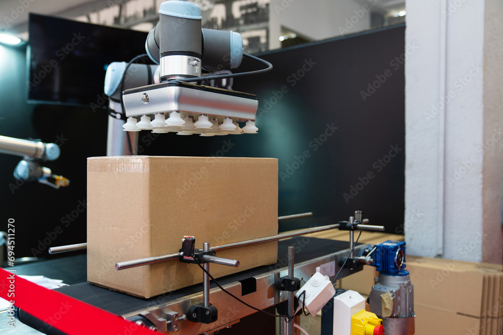 Poster Robot arm moves box in an automatic warehouse