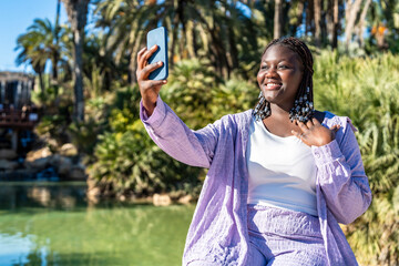 Portrait of young African  woman using smartphone outdoors