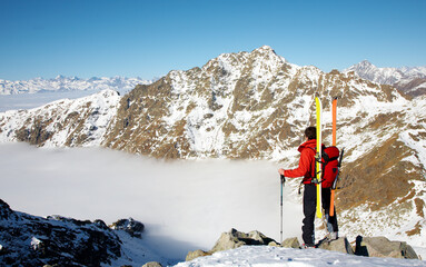 A captivating image of an adventurer in the midst of a ski expedition on a breathtakingly beautiful mountain. The adventurer is fully equipped, holding skis and poles.