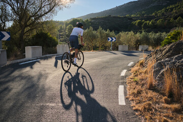 Male cyclist is conquering the challenging uphill terrain on his gravel bike.Sportsman training...