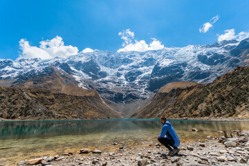 Rear view of man traveler in front of Humantay lake in Cusco. Trekking concept