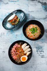 Rice with chicken, dashi broth and flatbread with beef and vegetables on a table.