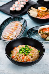 Fototapeta premium Rice with chicken, dashi broth, sushi maki rolls with shrimp, calamari and flatbread with beef and vegetables.