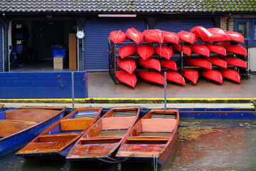 Stacked canoes and punting boats stored in a sports club creating abstract colors and shapes in...