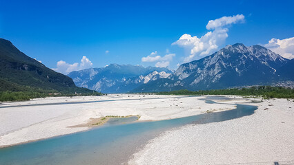 Scenic view of braided river Tagliamento running through mountainous landscape with in Friuli-Venezia Giulia, Italy, Europe. Clear blue water flowing in natural wilderness. Peaceful serene scene