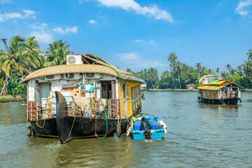 Fototapeta na wymiar Indian traditional houseboats floating on Pamba river, with palms at the coastline, Alappuzha, Kerala, South India