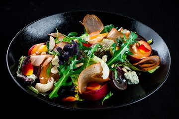 Green salad with bacon, persimmon, arugula, olives, blue cheese, cashews and lettuce.