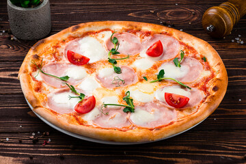 Pizza with ham, mozzarella cheese, tomatoes and microgreens, Italian cuisine.