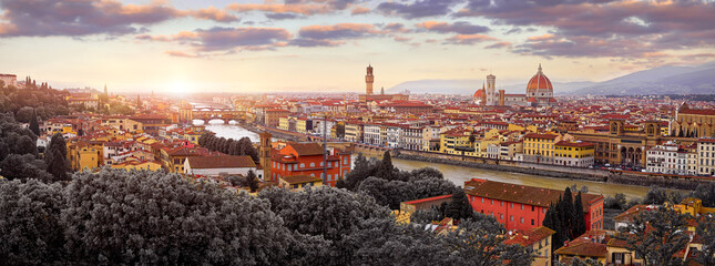 Florence (Firenze, Italy. Sunset panorama. Evening view at ancient city. Famous Ponte Vecchio bridge on river Arno scenic clouds and sky. Duomo Santa Maria del Fiore cathedral, Palazzo Tower - obrazy, fototapety, plakaty