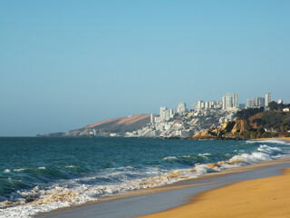 Waves breaking on the shore with view of Concón and Reñaca in the background