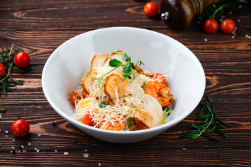 Caesar salad with shrimps, parmesan cheese, eggs, lettuce, tomatoes and croutons, Italian dinner.