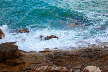 Seascape. A sea wave hits the rocky shore, view from above. Beautiful background.
