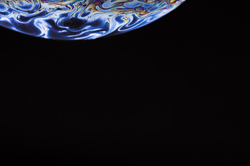 Soap bubble. Streaks of fluid. Surface with psychedelic colors. Abstract background. Space model. Virtual reality planet. Free space for an inscription. Conceptual image of the universe.