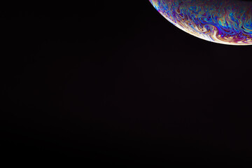 Soap bubble. Streaks of fluid. Surface with psychedelic colors. Abstract background. Space model. Virtual reality planet. Free space for an inscription. Conceptual image of the universe.