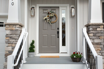 Country Farmhouse Front Porch Entryway Featuring a Gray Paneled Door Adorned with a Rustic Wreath