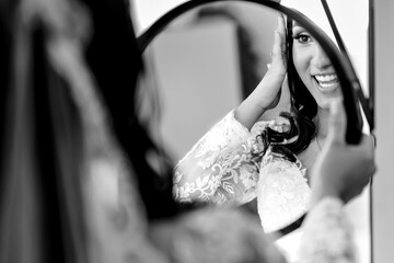the silhouette of a bride looking in the mirror