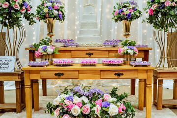 Fototapeta na wymiar a table decorated with pink, purple and white sweets and flowers
