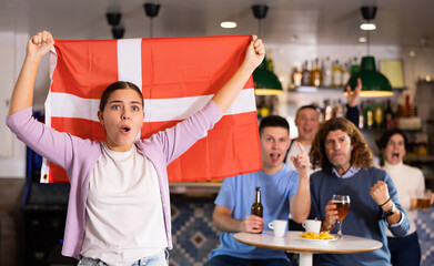 Joyful fans of the Denmark team celebrating the victory in the night bar