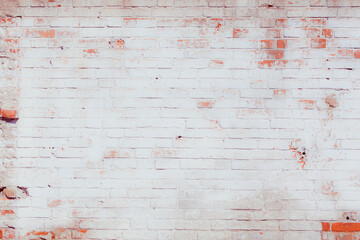 The wall is made of red brick locally painted white. Covered with white plaster. Free space for an inscription. Can be used as a background or poster. Fragment of a wall with bumps and peeling paint. - obrazy, fototapety, plakaty