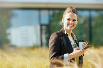 happy woman employee near office building using smartphone
