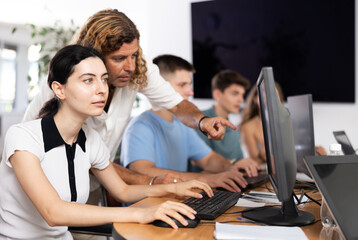 Fototapeta premium Student and teacher collaborate on computer to solve complex equations.