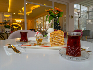 Medovik cake and Turkish tea for two at the table.