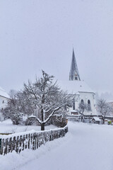 View of snow-covered Bramberg, with the village church in Salzburger Land, Austria,