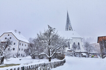 View of snow-covered Bramberg, with the village church in Salzburger Land, Austria,