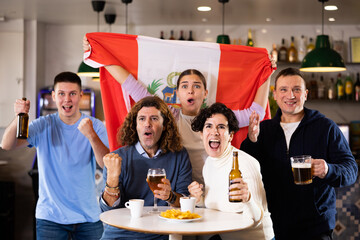 Enthusiastic Peruvian fans scream with joy in a beer bar. Peruvian win
