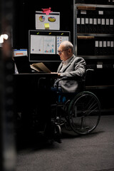 Senior wheelchair user checking annual profit revenue paperwork before business consulting meeting....
