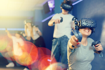 Young woman with handheld controllers in hands clearly excited and engaged in virtual world...
