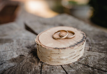 wedding rings on a wooden table - obrazy, fototapety, plakaty