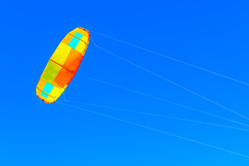 Colorful paraglider in the blue sky. Kitesurfing in the summer day 