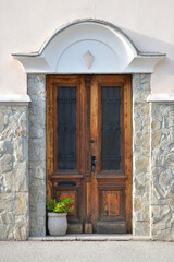 Beautiful wooden door and green plant in a stone pot.