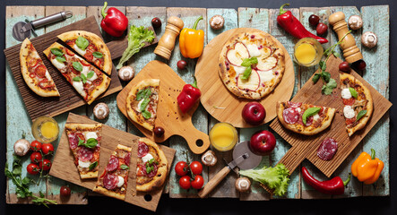 Pizza slices on wooden boards with vegetables, greens and mushrooms