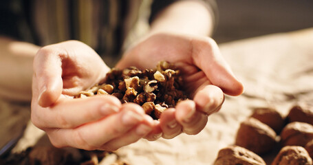 Close-up shot of a woman holding a handful of walnuts.