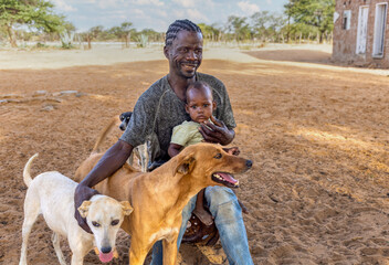 village , african family father and kid together with the dogs at the farm, ghetto houses in the...