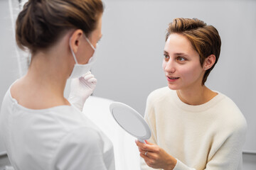 A young woman consults a beautician about her face.
