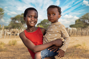 family, african girls at the farm, kraal with goats in the background, Kalahari small livestock in...