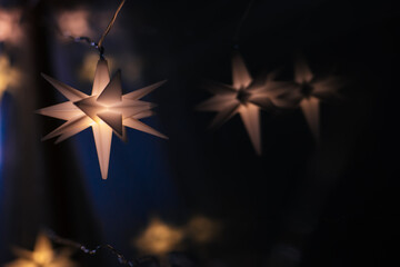  Christmas shining star with warm light on a black background.Christmas decoration on a black...