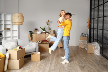 Young couple hugging in room on moving day