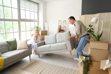 Deurstickers Mature couple carrying sofa in room on moving day © Pixel-Shot