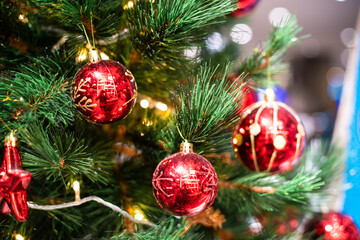 Obraz na płótnie Canvas Christmas celebration concept with red ball hanging decorate gift on pine tree blurred background