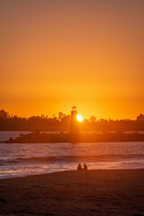 Fototapeta na wymiar Couple watching sunset at Walton Lighthouse in Santa Cruz, CA