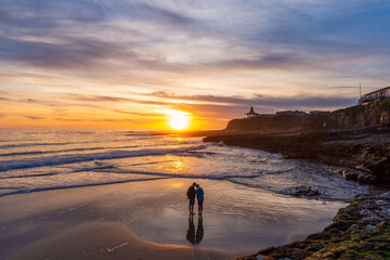 Couple enjoying the sunset on the beach in Santa Cruz, CA