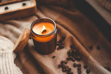 Burning candle and coffee beans, cozy photo