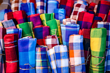 Colorful Thai Style Loincloths Fabric (Pha khao ma) folded in the basket, handicraft of local residents of Thailand, traditional made from cotton or silk.