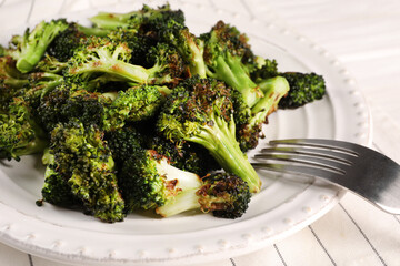 Tasty fried broccoli and fork on table, closeup