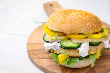 Tasty vegan burger with vegetables, sauce and patty on white background, closeup