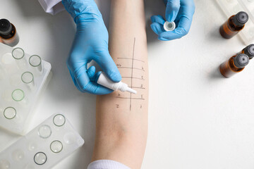 Doctor doing skin allergy test at light table, top view